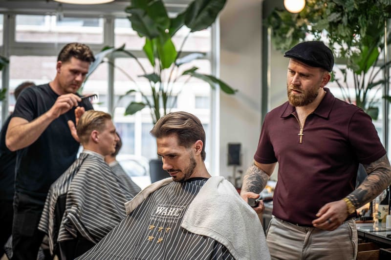 Barberos trabajando juntos en la barbería